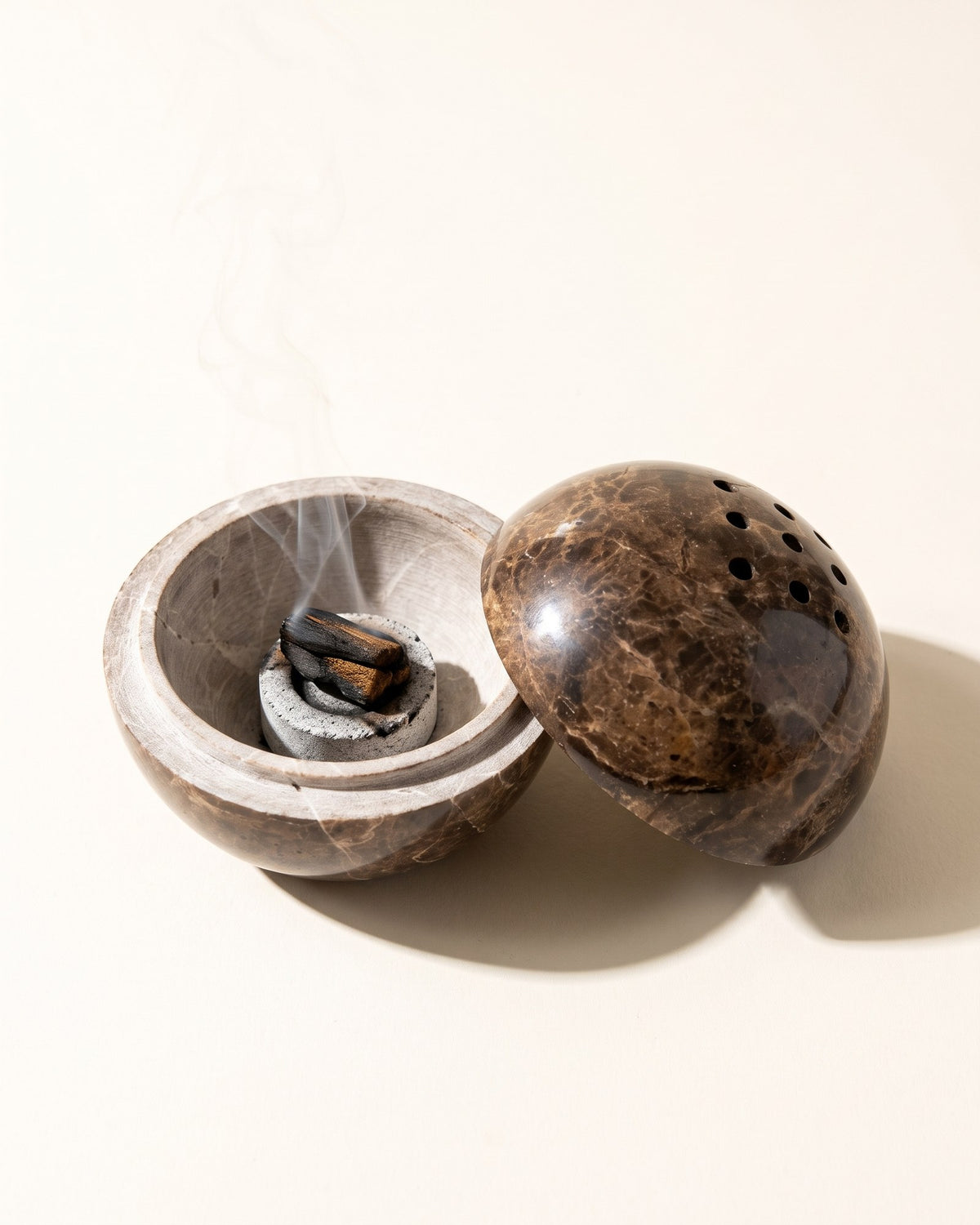 The globe opened in half with a charcoal disc and bakhoor inside