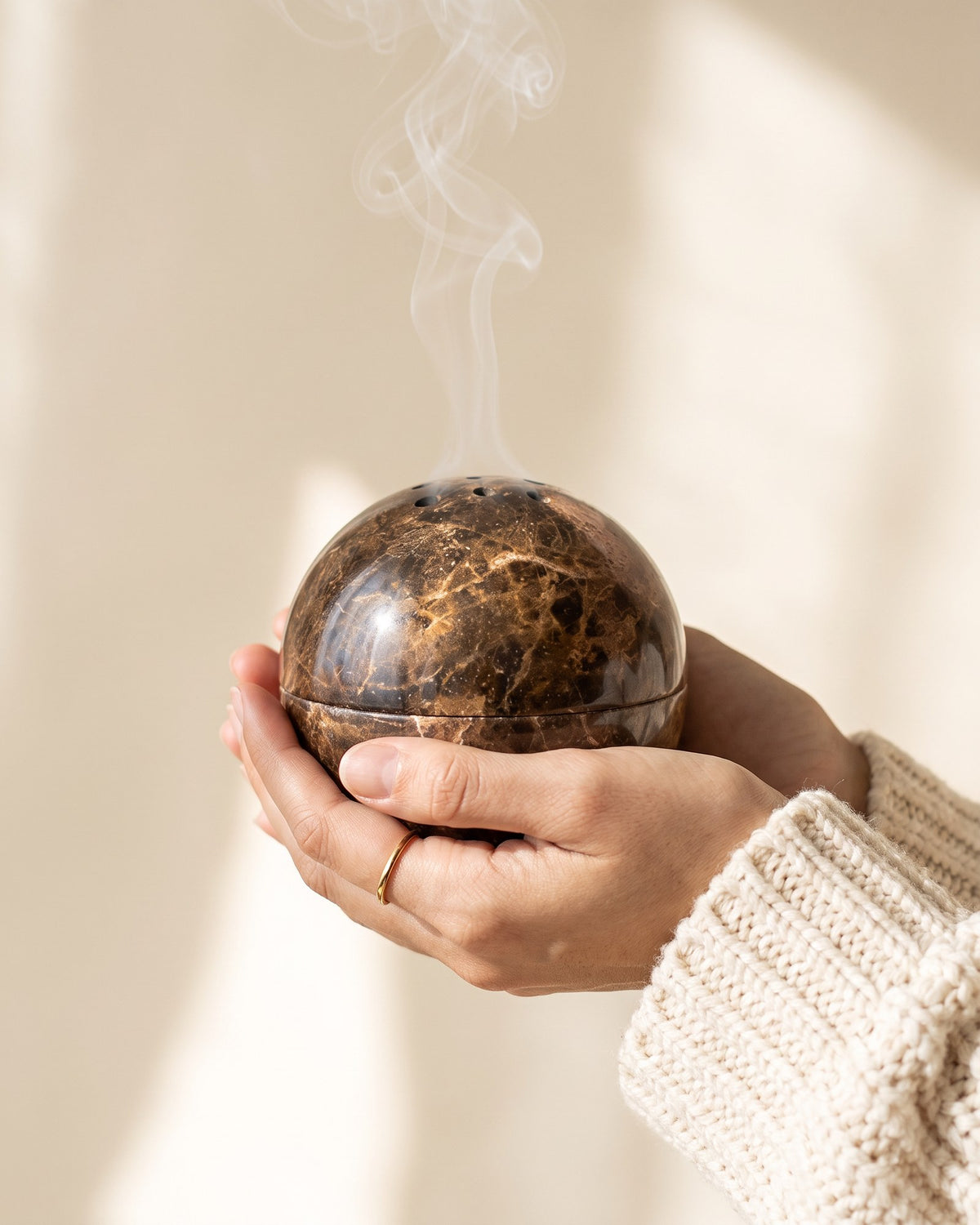 The marble globe held in two hands to show its size